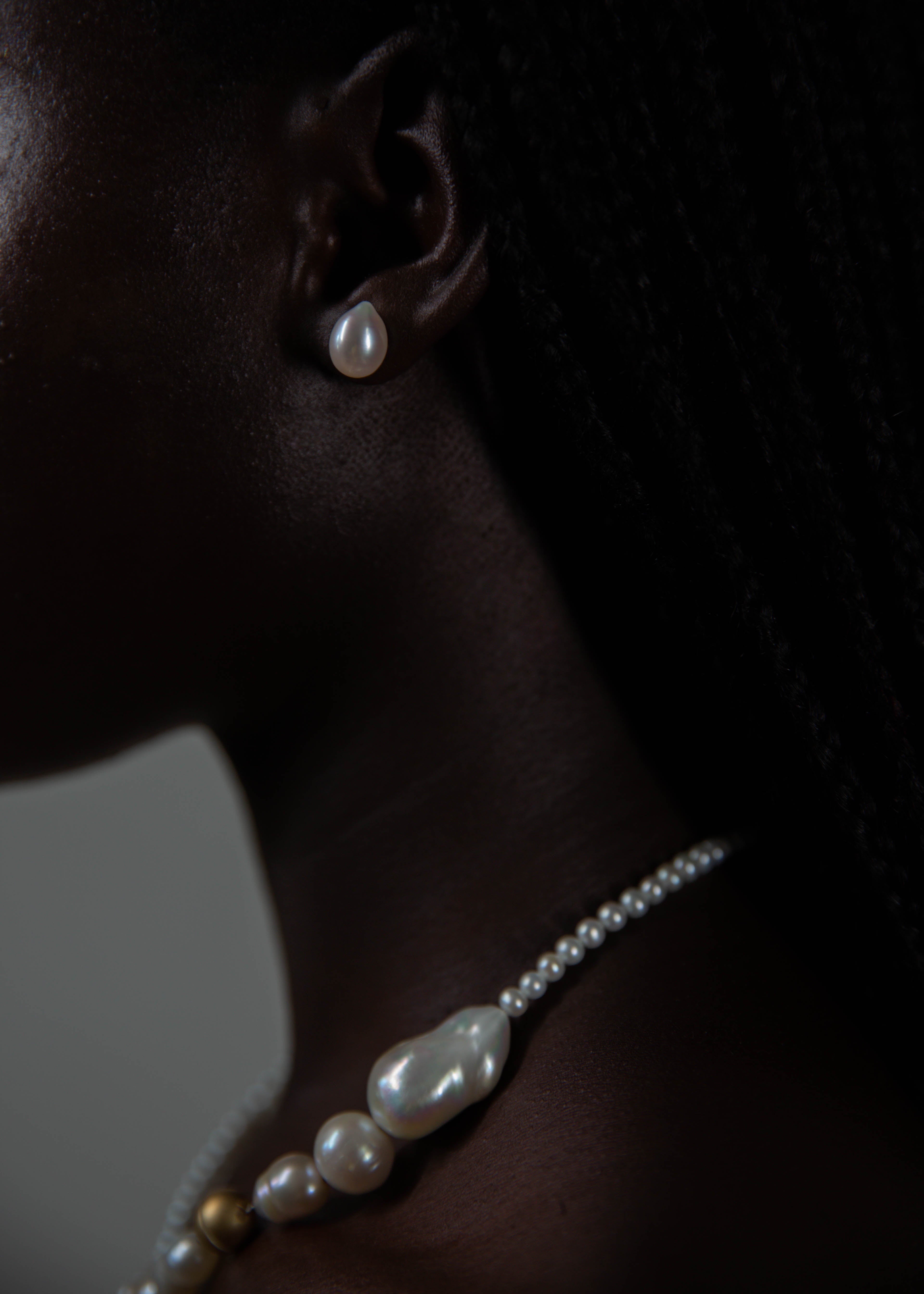 Model wearing handcrafted pearl necklace and earring from the side