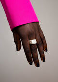 Handcrafted silver signet ring worn on a hand with pink blazer 