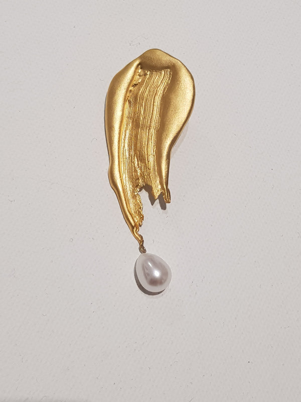 Handcrafted Gold Brooch with a pearl on a light gray background