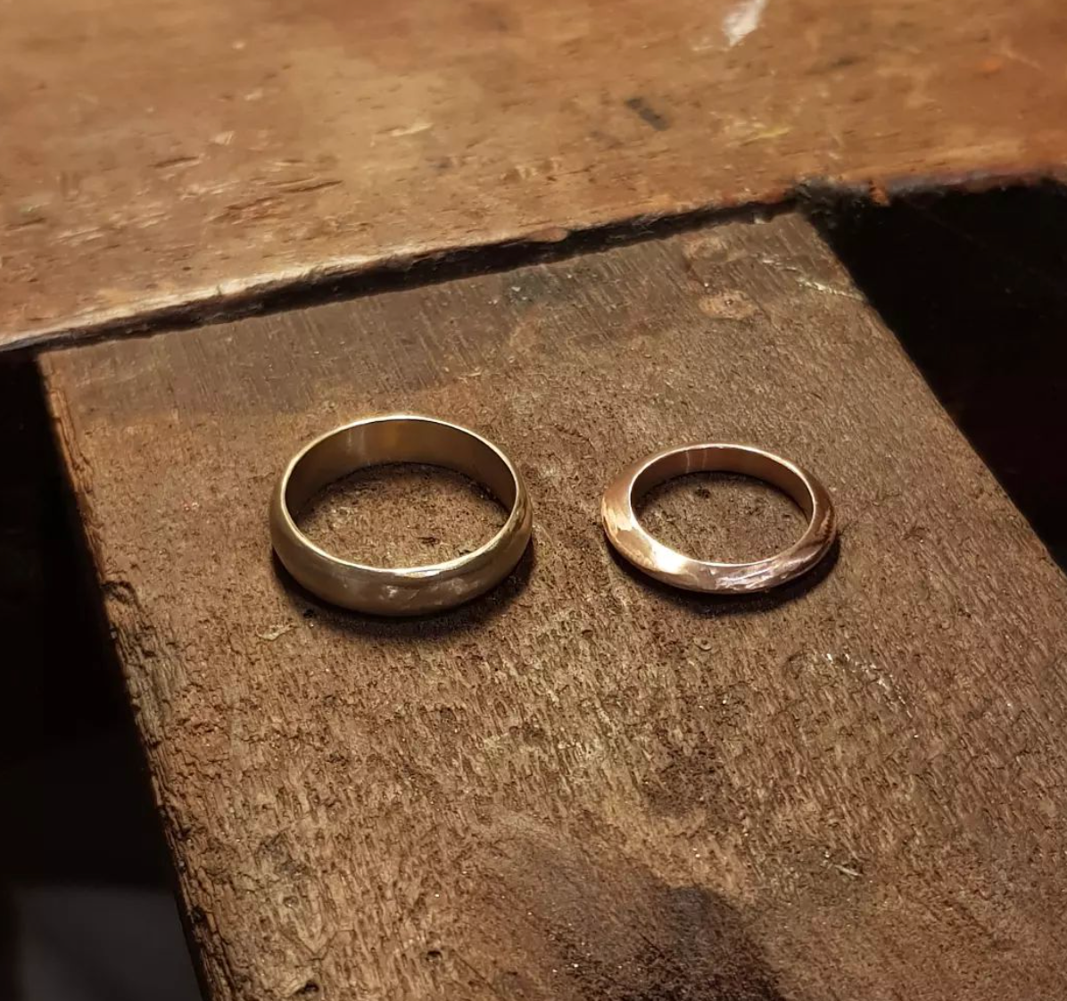 Two  handcrafted silver wedding rings on a wooden surface