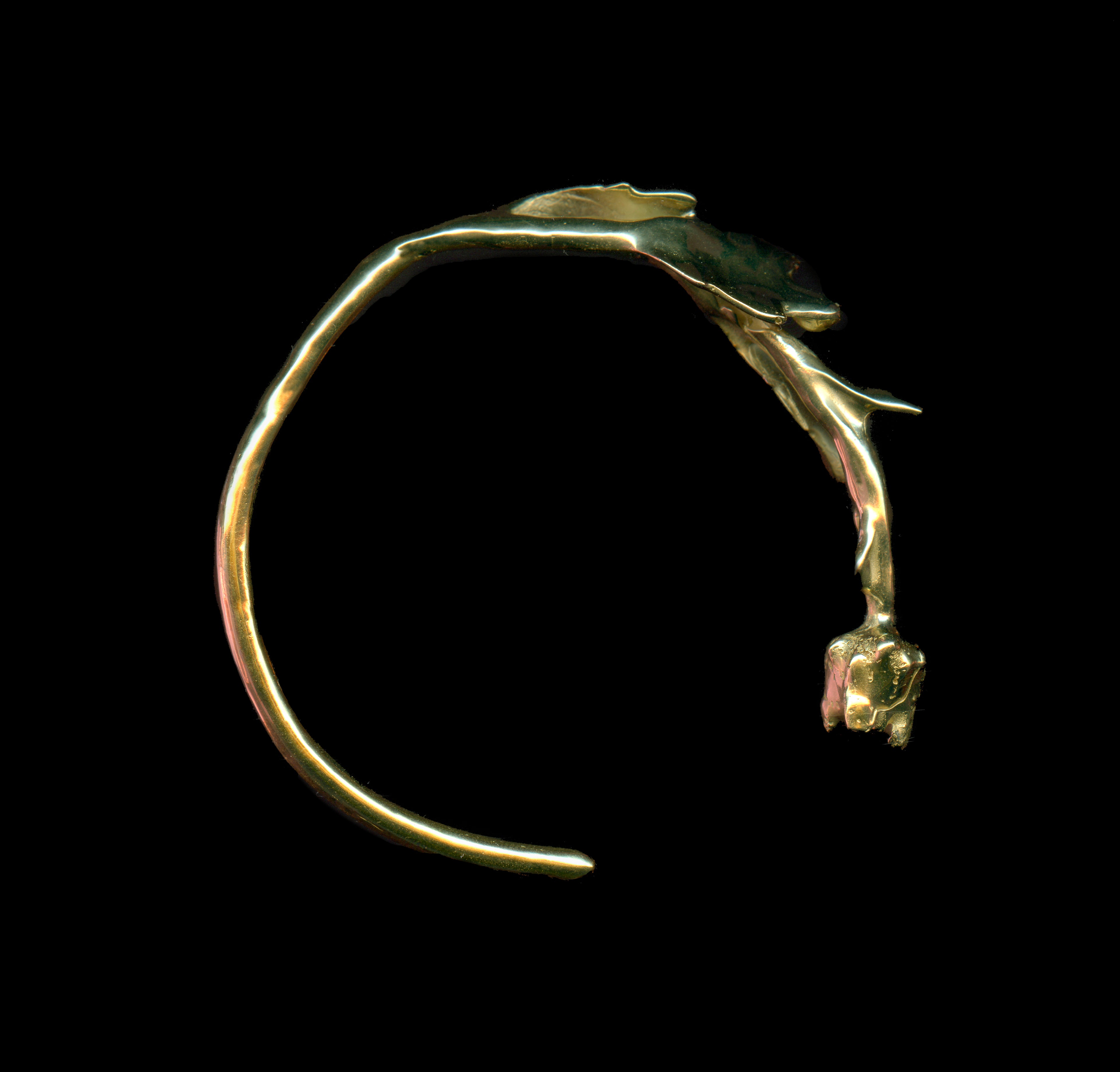 Handcrafted gold florero bracelet on black background