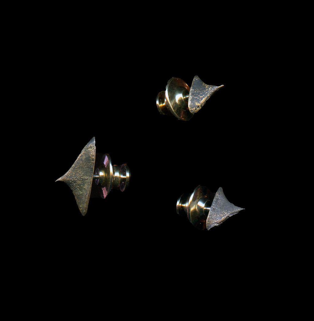 Three handcrafted bronze thorn brooches on black background