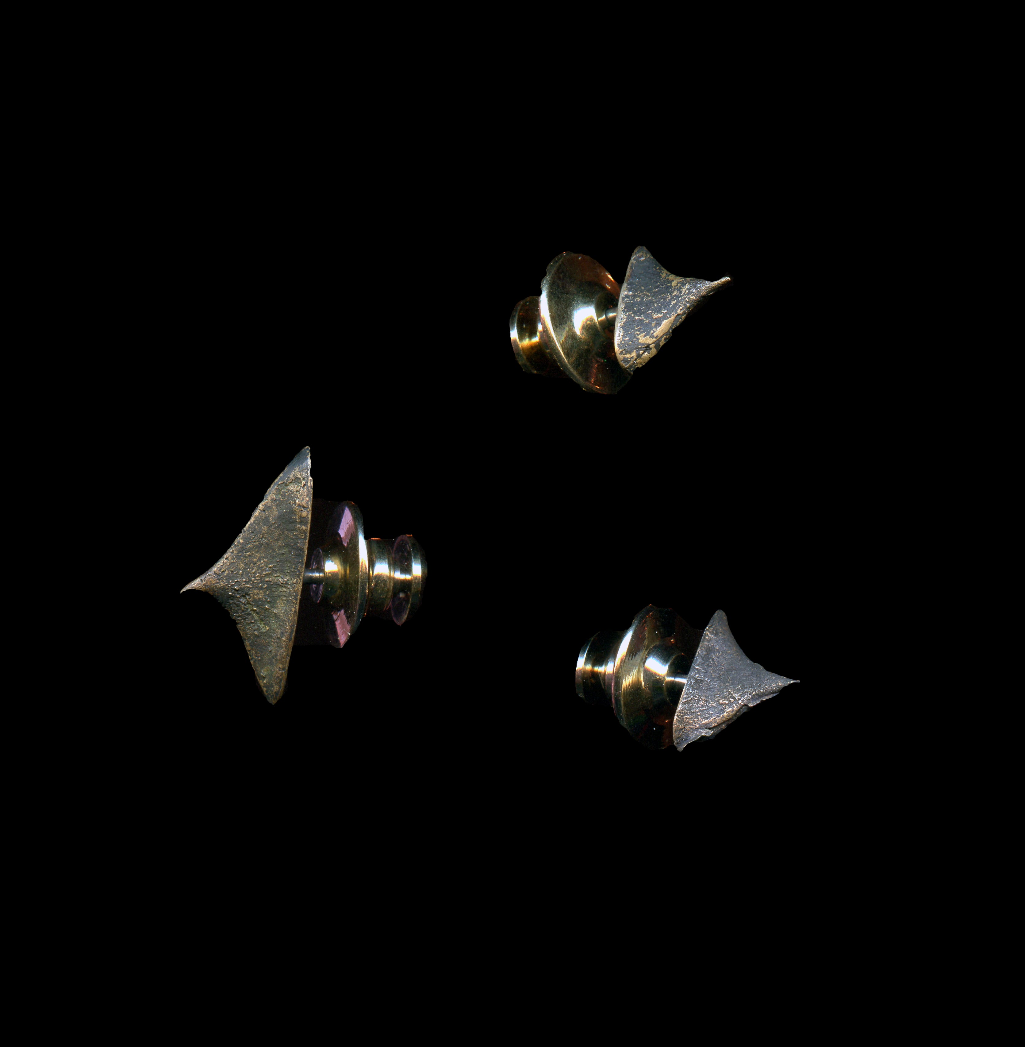 Three handcrafted bronze thorn brooches on black background