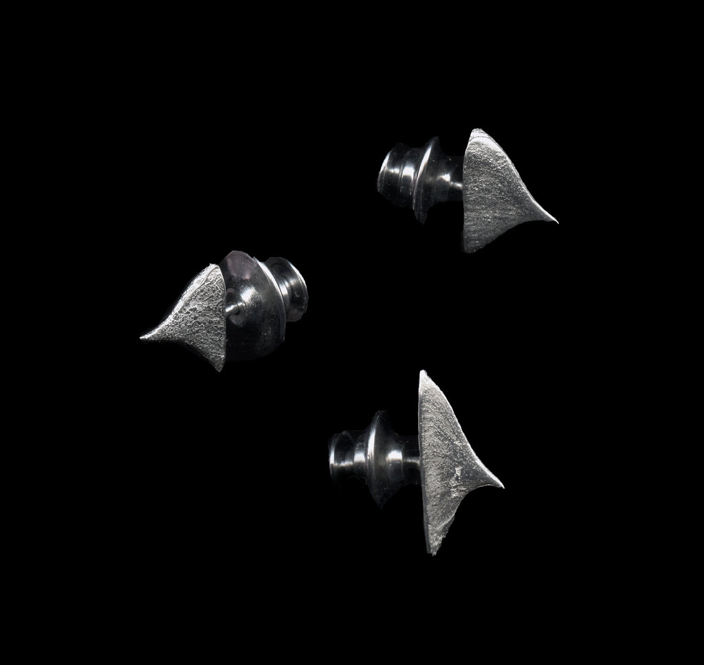 Three handcrafted silver thorn brooches on black background