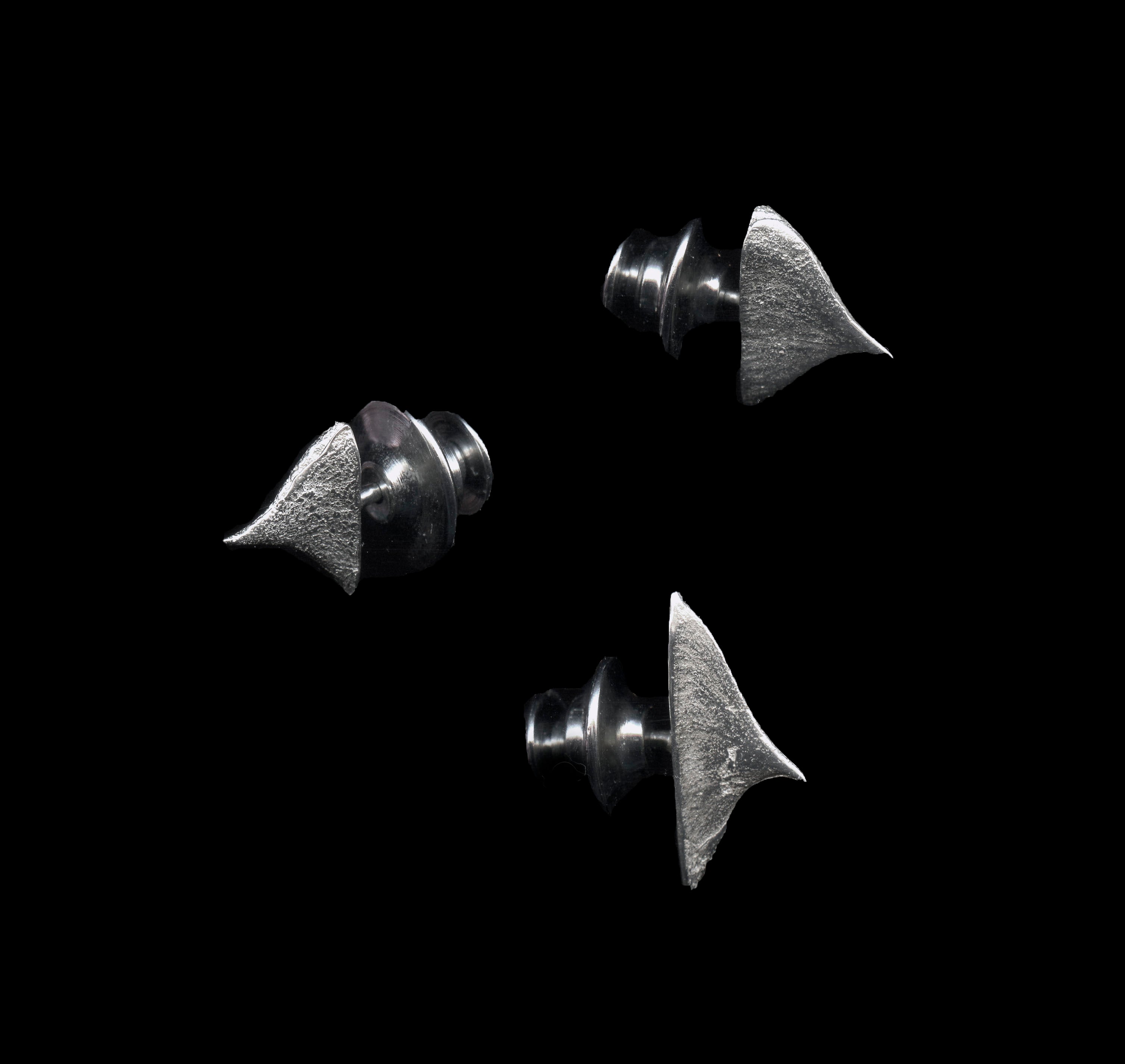 Three handcrafted silver thorn brooches on black background