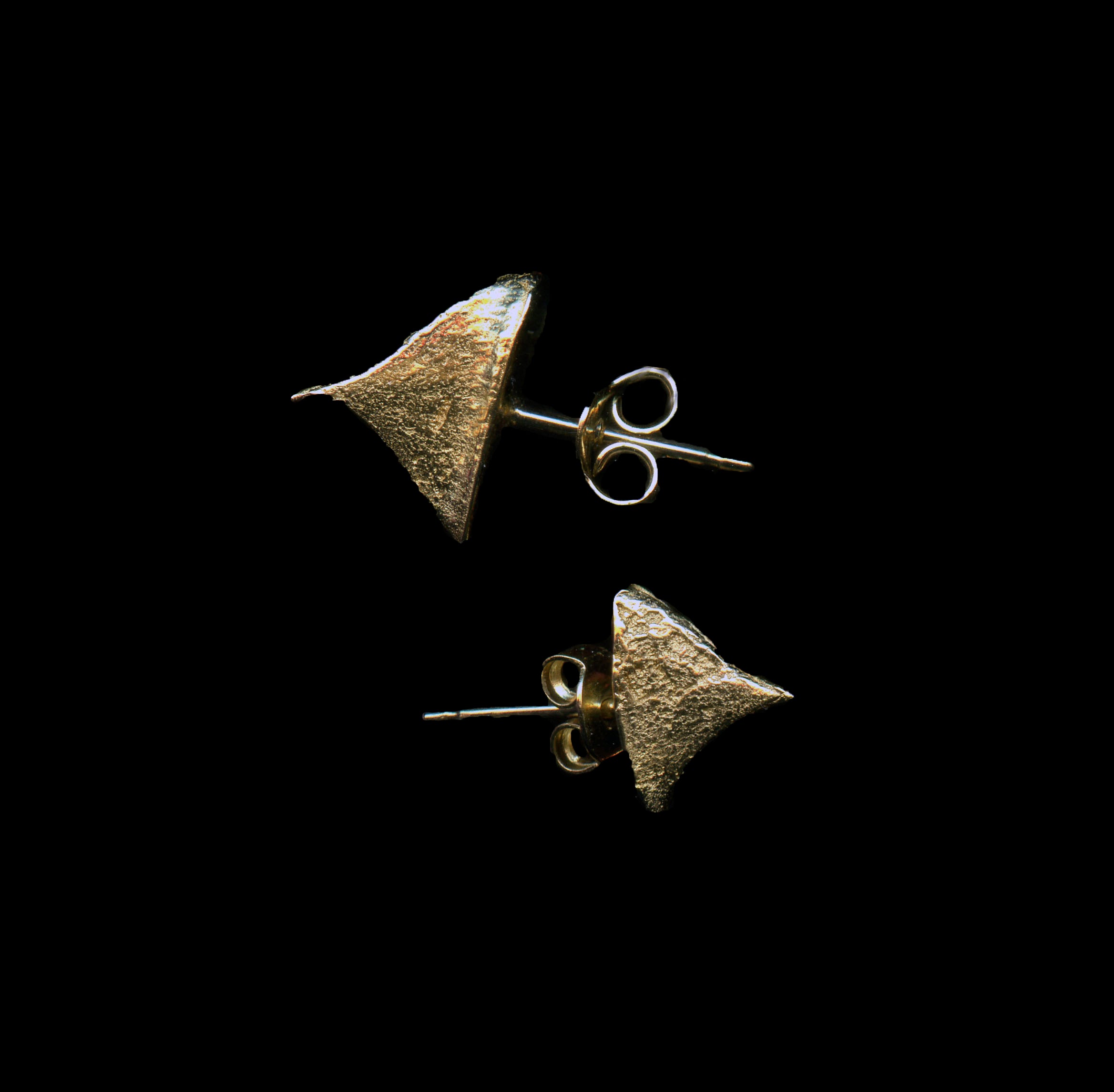 handcrafted gold thron earrings on black background