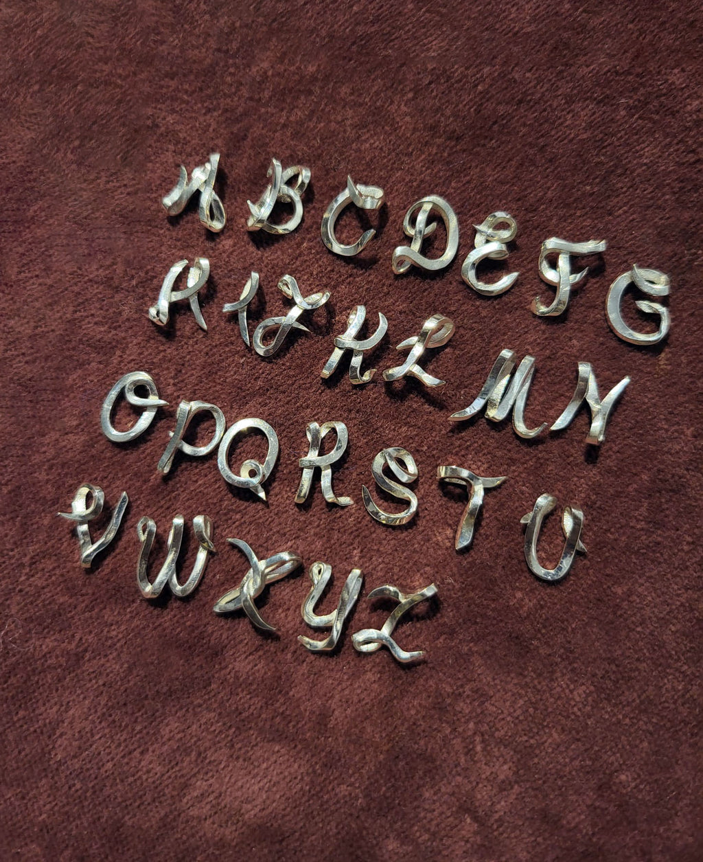 handcrafted Silver letters on a red velvet background