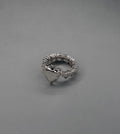 handcrafted Silver ring with heart designs on a gray background
