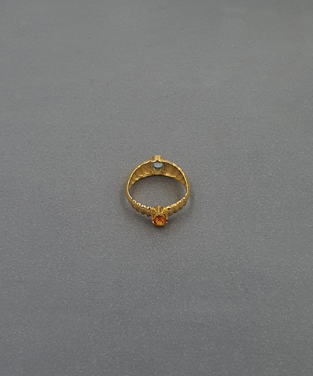 handcrafted gold ring on grey background
